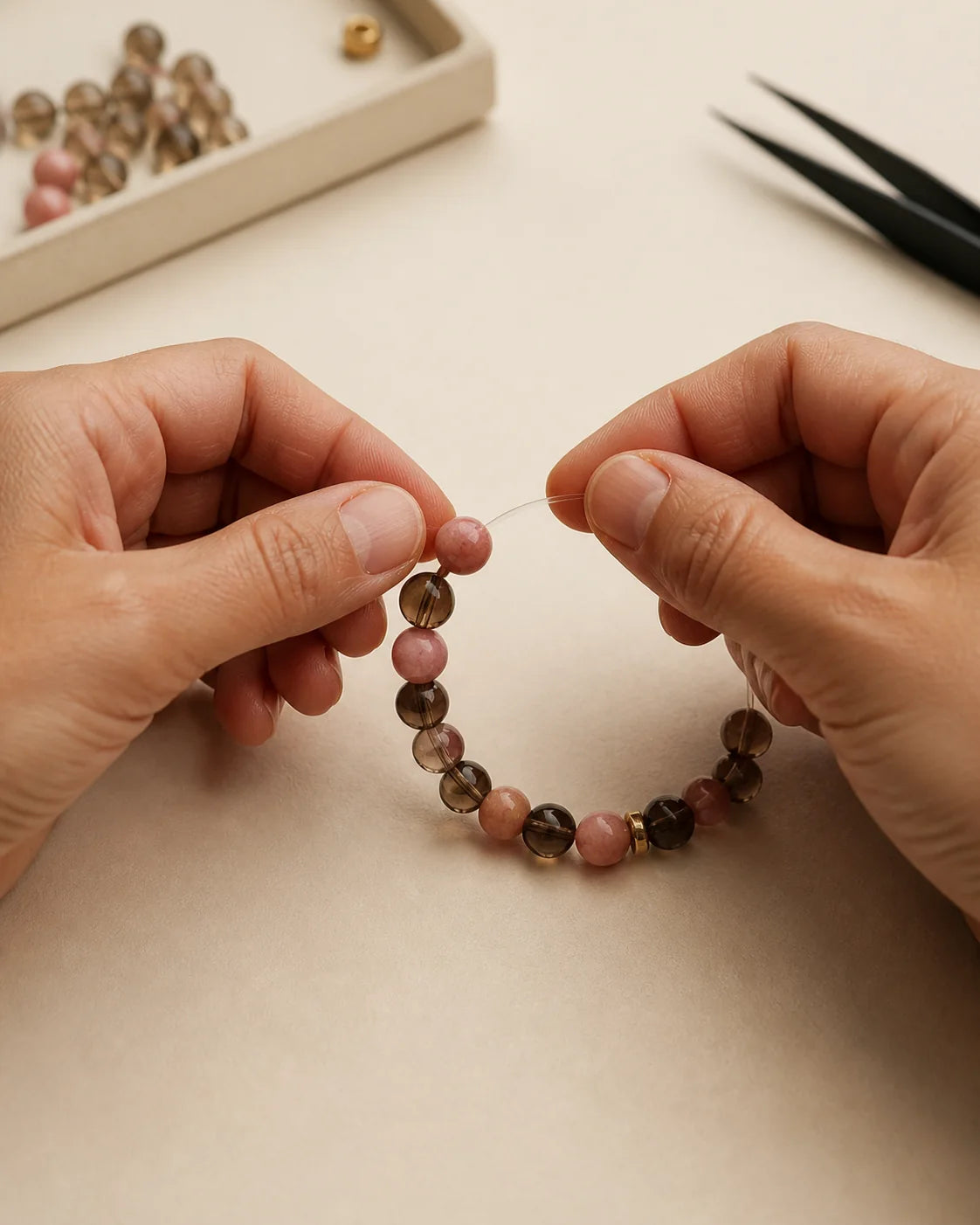 Hands assembling a gemstone bracelet in the studio